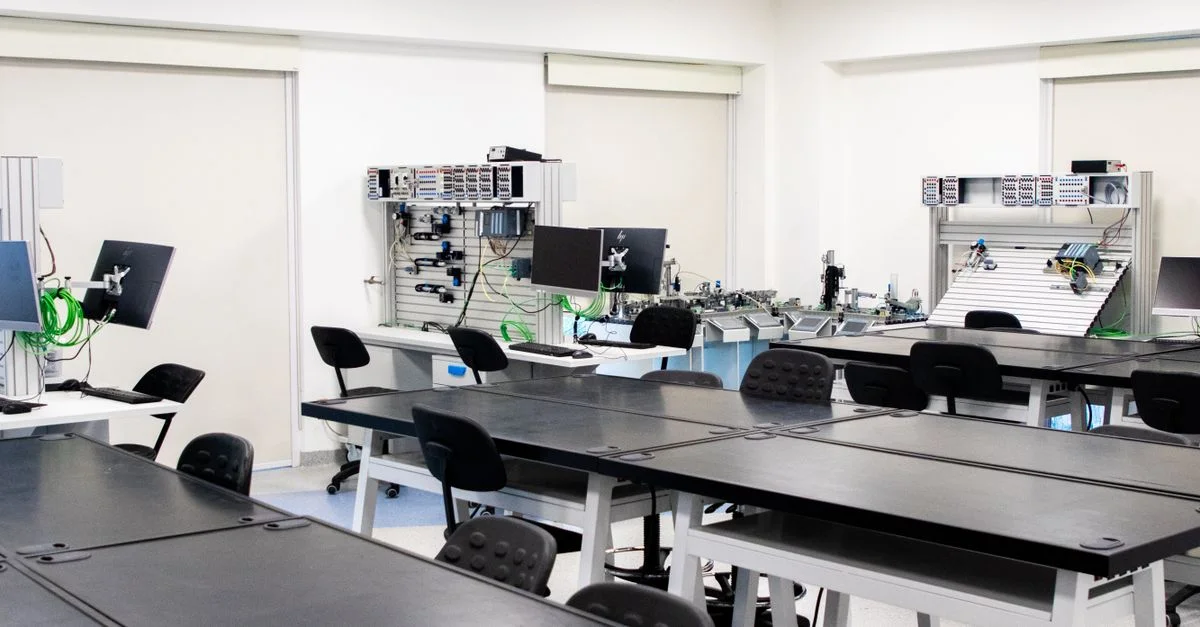Laboratoire de technologie spacieux et moderne avec des bureaux et du matériel informatique, idéal pour les environnements éducatifs.