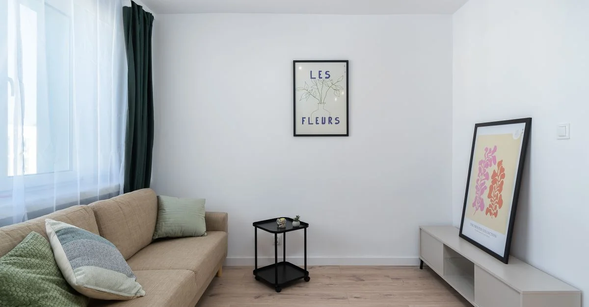 Un salon minimaliste élégant avec des œuvres d'art et un canapé confortable.