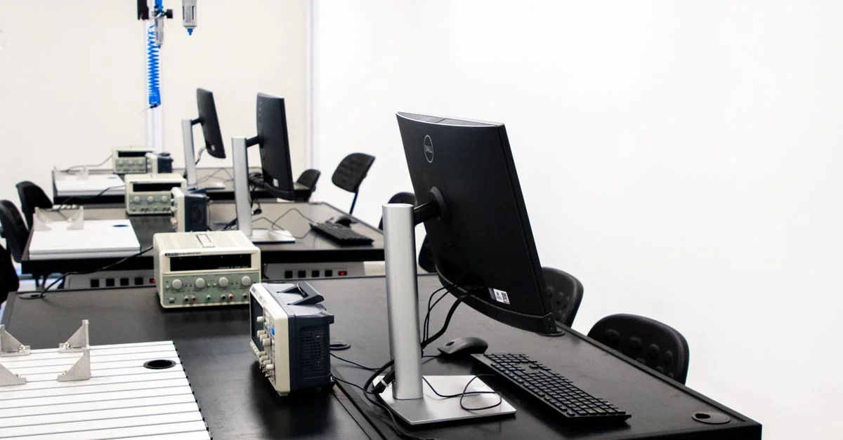 Un laboratoire électronique contemporain avec des ordinateurs, des écrans et divers équipements techniques sur les bureaux.
