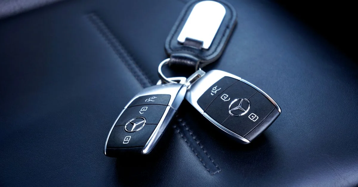 Deux clés de voiture Mercedes Benz reposant sur un siège en cuir luxueux, mettant en valeur l'élégance et le design.