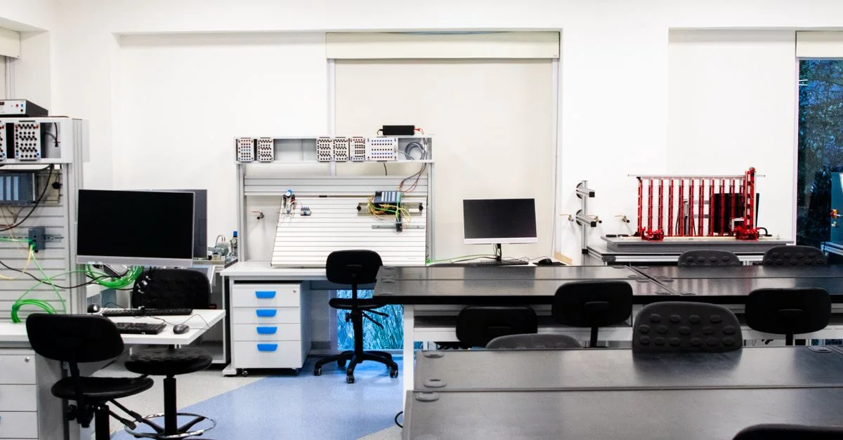 Laboratoire moderne bien éclairé et équipé de technologies, avec des ordinateurs, des stations de travail et des bureaux.